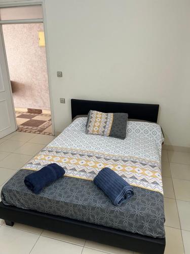 a bed with two pillows on top of it at Appartement spacieux avec terrasse à 10 minutes du centre in Tangier