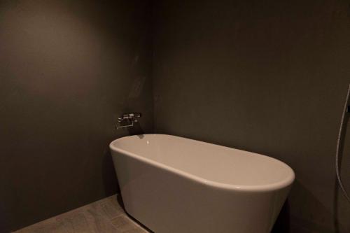 a bathroom with a white bath tub in a room at Satoyama Villa Honjin - Vacation STAY 17846 in Matsumoto