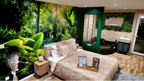 a bedroom with a bed in a room with plants at Appartement Chambre Cosy - Jacuzzi - Little Room Vendôme in Vendôme
