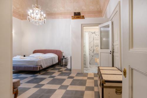 a bedroom with a bed and a checkered floor at Donna Zaira rooms&suites in Maglie