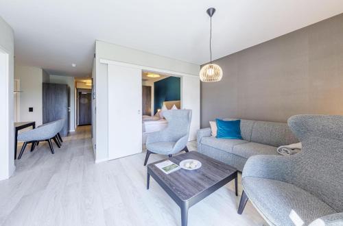 a living room with a couch and a table at Boddenperle - 5-Sterne-Ferienwohnung mit Ostbalkon, 2 Bädern & Strandhaus-Charme in Wustrow