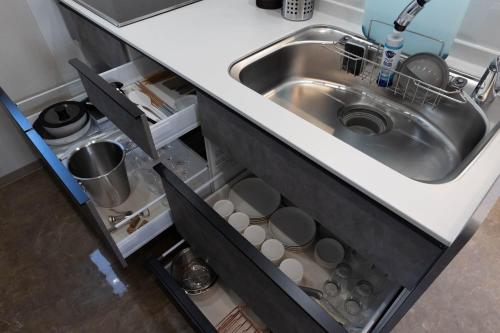 a kitchen counter with a sink and dishes in it at Kanasha Building A - Vacation STAY 49732v in Ōkachi