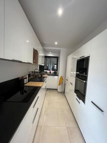 - une grande cuisine blanche avec des appareils en noir et blanc dans l'établissement À louer Maison de vacances, à Le Touquet-Paris-Plage