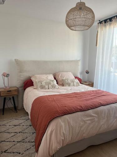 une chambre avec un grand lit avec une couverture rouge dans l'établissement À louer Maison de vacances, à Le Touquet-Paris-Plage