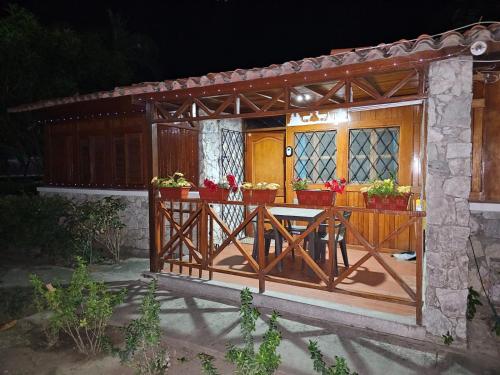a wooden porch with a table and flowers on it at Chalet Completo para Familias Condominio Campestre Privado con Piscinas, wifi, AC in Santa Marta