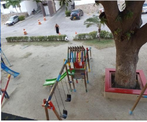 a group of playground equipment next to a tree at Chalet Completo para Familias Condominio Campestre Privado con Piscinas, wifi, AC in Santa Marta