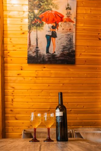 a bottle of wine and two glasses on a table at Eco cottage sunrise merisi in Merisi