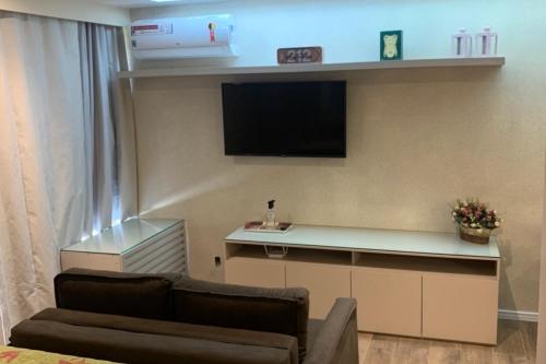 a living room with a couch and a flat screen tv at Flat no Life Resort a Beira Lago in Brasilia
