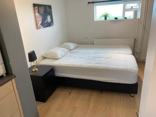 a bed in a small room with a window at Cosy apartment in Selfoss