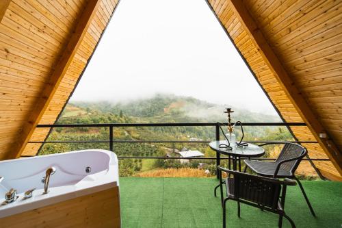 a bathroom with a tub and a table and a chair at Eco cottage sunrise merisi in Merisi
