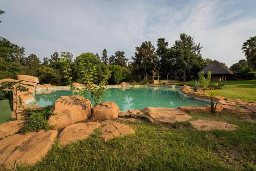 una piscina con rocas en un patio en Kianga Lodge & Venue, en Centurion