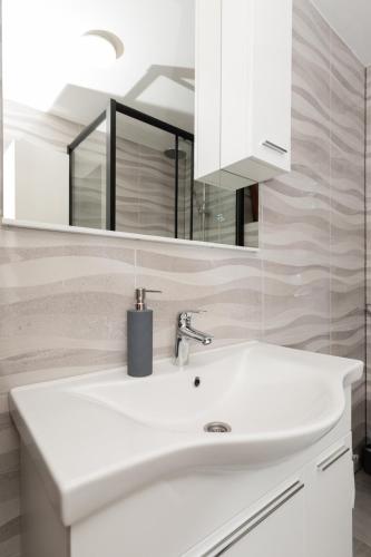 a bathroom with a white sink and a mirror at Lov&Mar apartment in Cvitović