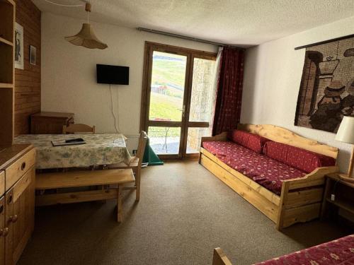 une chambre avec un canapé, une table et une fenêtre dans l'établissement Résidence Pierre De Soleil - Studio pour 2 Personnes 00, à Mâcot La Plagne