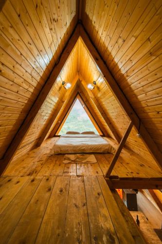 a large wooden attic room with a window at Eco cottage sunrise merisi in Merisi