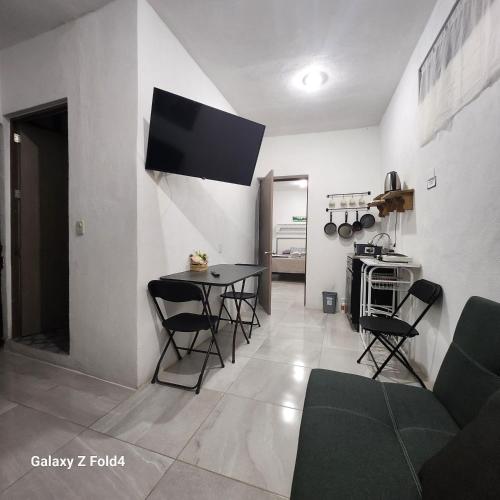 a living room with a table and chairs and a tv at Casa De Linda Vista in Guanajuato