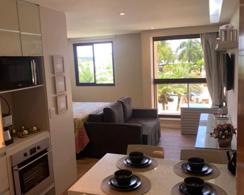 a small living room with a couch and a table at Flat no Life Resort a Beira Lago in Brasilia