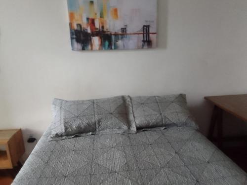 a bed in a room with a picture on the wall at Apartamento 112 Centro Consolaçao in Sao Paulo