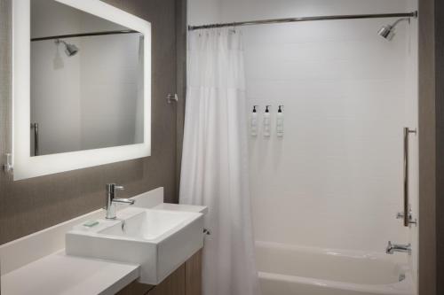 a bathroom with a sink and a shower with a mirror at SpringHill Suites by Marriott Bowling Green in Bowling Green