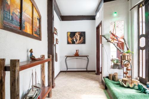 a hallway with paintings on the wall and a table at Pousada Portal de Búzios in Armacao dos Buzios