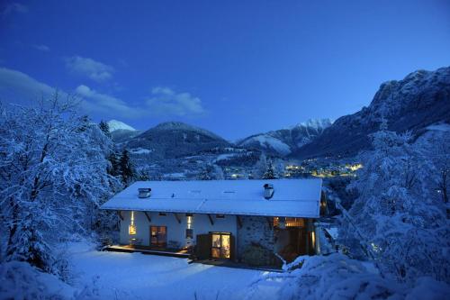 a small house in the snow at night at B&B Mas de Lagorae in Tesero