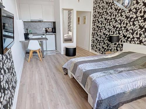 une petite chambre avec un lit et une cuisine dans l'établissement Appart Hôtel - Vue unique, à Vichy