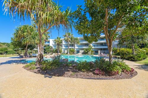 a resort with a swimming pool and palm trees at Cotton Beach 53 by Kingscliff Accommodation in Casuarina