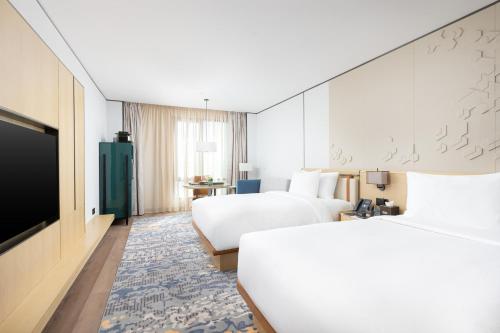 a hotel room with two beds and a flat screen tv at Braira Al Rass بريرا الرس in Al Rass