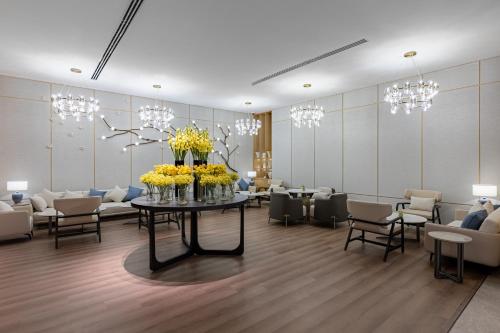 a waiting room with a table with yellow flowers on it at Braira Al Rass بريرا الرس in Al Rass