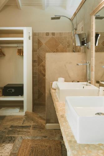 a bathroom with a white sink and a tub at La Villa Hibiscus, Saint Martin in Cul de Sac