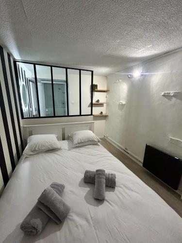 une chambre avec un grand lit blanc avec des serviettes dessus dans l'établissement Nancy Bricks Stan, à Nancy