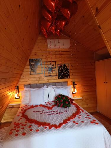 a bedroom with a bed with red flowers on it at Chalés Laraland in Campos do Jordão