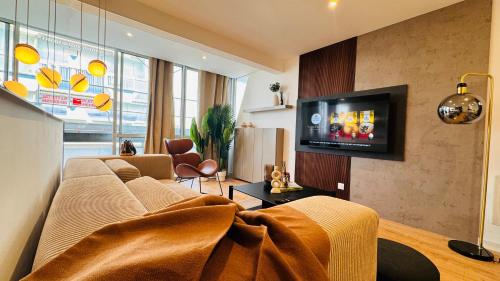 un salon avec un canapé et une télévision sur un mur dans l'établissement Appartement 50m de la plage et toutes commodités, plein centre ville et silencieux, à La Grande Motte