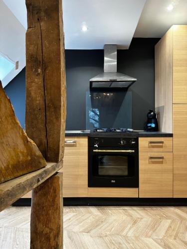 La cuisine est équipée d'un four noir et de placards en bois. dans l'établissement La Casa D or, à Guilliers