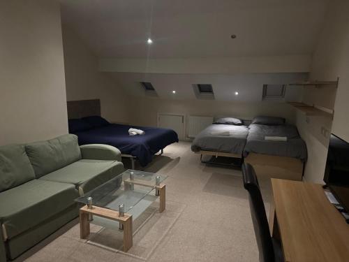 a living room with two beds and a couch at Seaford Guest House XXX in Stoke on Trent