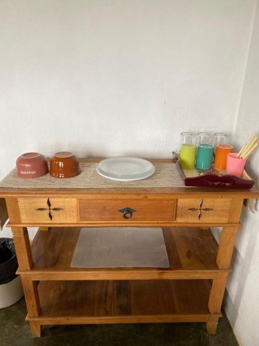 a wooden table with a plate and glasses on it at Pousada Vale das Araucárias in Santo Antônio do Pinhal
