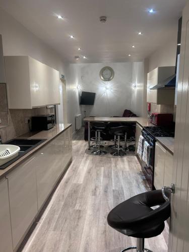 a kitchen with a table and a stool in it at Seaford Guest House XXX in Stoke on Trent