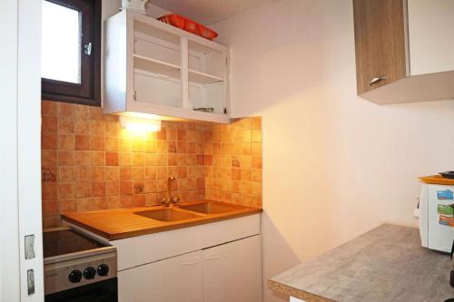 une petite cuisine avec un évier et une cuisinière dans l'établissement Résidence La Mazeliere - Studio pour 4 personnes MAE-0774, aux Orres