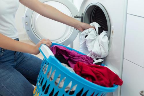 a woman loading a laundry basket into a washing machine at Candlewood Suites Middletown - Goshen by IHG in Middletown