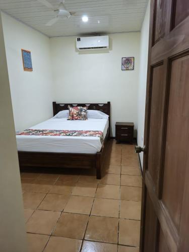 a bedroom with a bed in a room with a door at Tropical Twins Apartment in Quepos