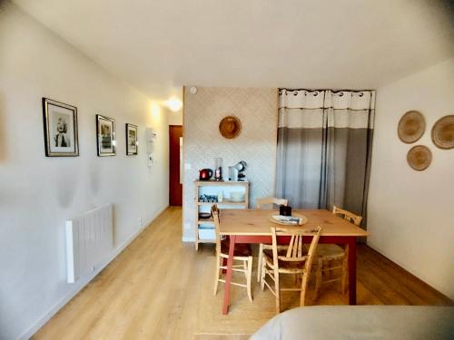une salle à manger avec une table et des chaises en bois dans l'établissement Charmant studio rénové 3 couchages Arcachon centre ville, à Arcachon