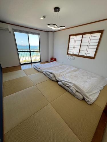 a bedroom with a bed in a room with windows at HOJO Brewing & Stays - Vacation STAY 17946 in Matsuyama