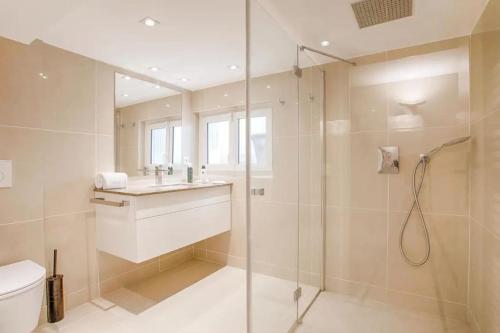 une salle de bain avec une douche, des toilettes et un lavabo dans l'établissement La charmante maison blanche, à Deauville