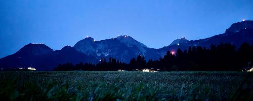 a field of grass with mountains in the background at Appartment Haus Einbergblick in Abtenau