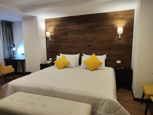 a bedroom with a large white bed with yellow pillows at LA TERRAZA INN in Huancavelica