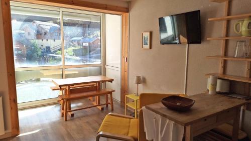 un salon avec une table et une grande fenêtre dans l'établissement Résidence St Moritz - STM601 - GRAND STUDIO 5 PERSONNES VUE PISTES MAE-2544, à Les Prés