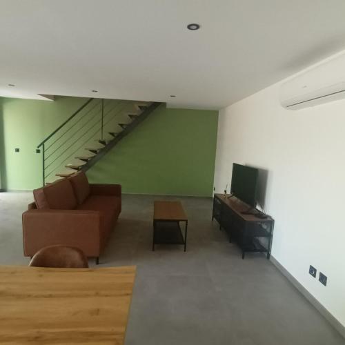 un salon avec un canapé et une télévision dans l'établissement Loft du Bugey, à Loyettes