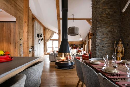 une salle à manger avec une cheminée et une table avec des chaises dans l'établissement Résidence Ariondaz Bleuet - Un penthouse au sommet, à Courchevel 1650 MAE-2404, à Courchevel