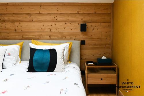 une chambre avec un lit et un mur en bois dans l'établissement Résidence Ariondaz Bleuet - Un penthouse au sommet, à Courchevel 1650 MAE-2404, à Courchevel