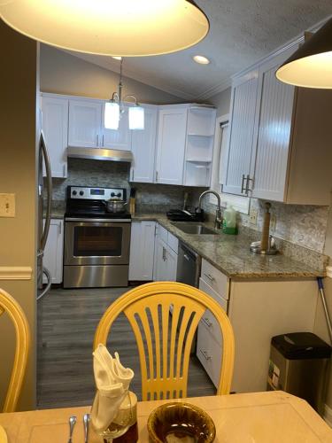 a kitchen with white cabinets and a table and chairs at Charming Family Luxury Home in Winchester
