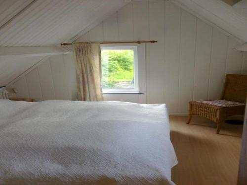 a bedroom with a white bed and a window at Dike House near Breskens with Stream Garden in Hoofdplaat